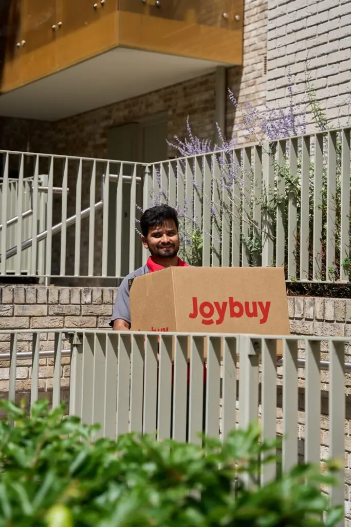 Courier delivering a Joybuy box up apartment steps