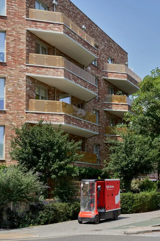 Joybuy JoyExpress electric cargo bike passing apartment blocks